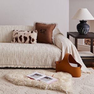 May include: A set of three ceramic mugs with a speckled, matte finish. The mugs are in shades of cream, light gray, and dark gray. Each mug has a simple, minimalist design and a rounded handle. The mugs are likely for coffee or tea.