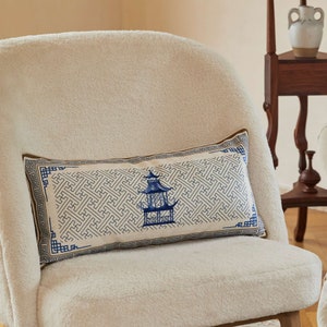 Peut inclure: Un coussin rectangulaire blanc avec un motif géométrique bleu et or et un motif de pagode bleu au centre.