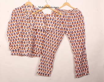 Può includere: Un pigiama bianco con stampa floreale blu e arancione. Il set comprende una camicia a maniche lunghe e pantaloni.