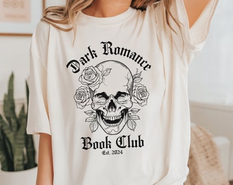 Puede incluir: Camiseta blanca con un gráfico negro de calavera y rosas. El texto "Dark Romance Book Club Est. 2024" está impreso debajo de la calavera.