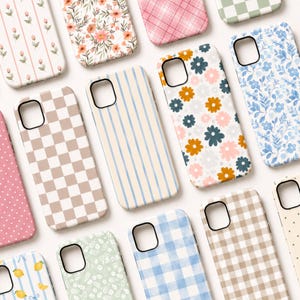 May include: A collection of smartphone cases featuring various patterns including floral prints, checkered designs, vertical stripes, polka dots, and gingham. The cases display a color palette of soft pink, blue, beige, white, and mustard yellow.