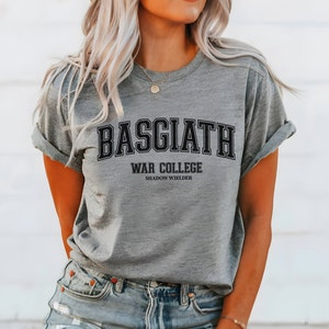 Op de afbeelding: Grijs T-shirt met zwarte tekst die "BASGIATH WAR COLLEGE SHADOW WIELDER" luidt