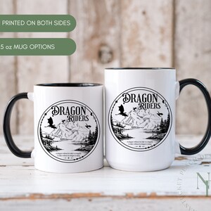 May include: Two white ceramic mugs with black handles and black rims. Both mugs feature a black and white illustration of a dragon with the text "Dragon Riders" in a circle. The text below the circle reads "A dragon without a rider is simply a rider without a dragon is dead."