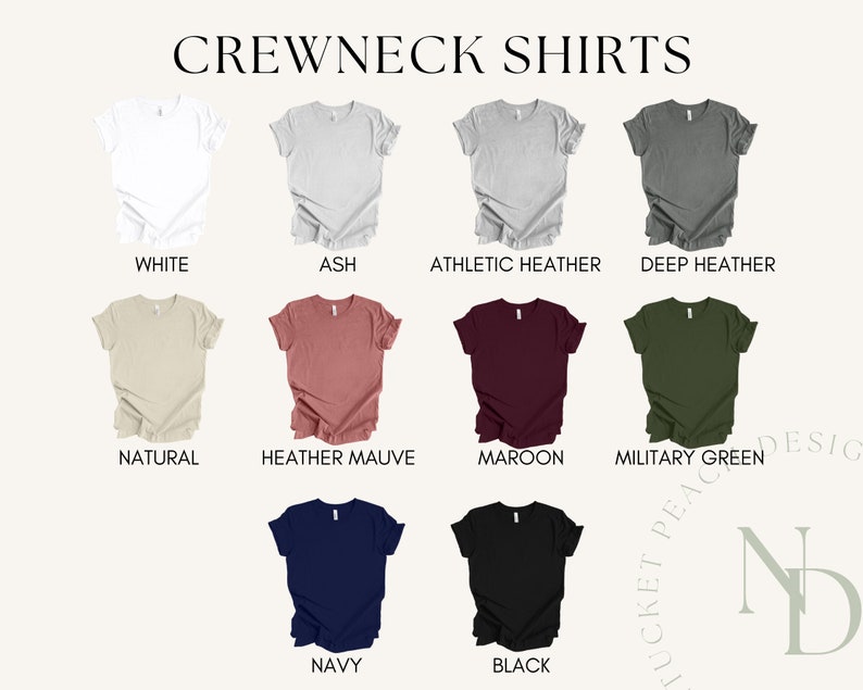Op de afbeelding: Een selectie van crewneck t-shirts in verschillende kleuren, waaronder wit, as, atletiek heather, donker heather, naturel, heather mauve, maroon, militaire groen, marineblauw en zwart.