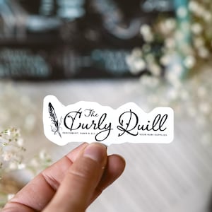 May include: A white sticker with black text that reads "The Curly Quill" with a feather design. The text below reads "Parchment, Pawn & All" and "Your Kumi Supplies".