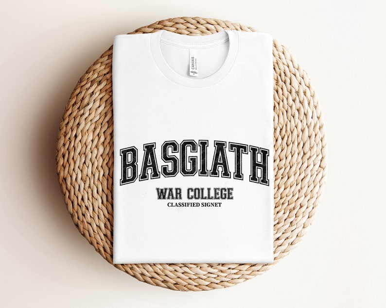 Op de afbeelding: Wit T-shirt met een zwarte grafische print met de tekst "Basgiath War College Classified Signet".