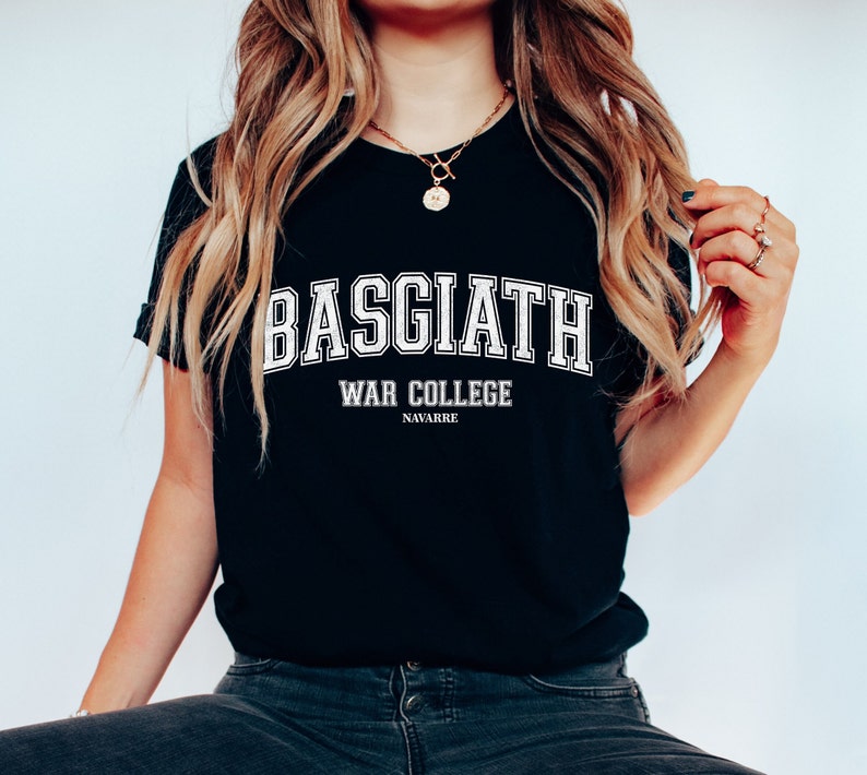 Op de afbeelding: Zwart T-shirt met witte tekst die "BASGIATH WAR COLLEGE NAVARRE" luidt.