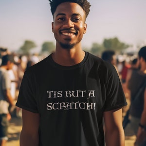May include: A black t-shirt with the text "Tis but a scratch!" printed in white.