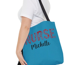 May include: A blue tote bag with the word "NURSE" spelled out in red with floral designs. The name "Michelle" is written in black below the word "NURSE".