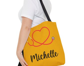 May include: A yellow tote bag with a red stethoscope forming a heart shape and the name "Michelle" printed in black.