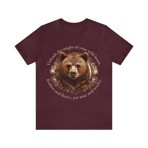 May include: A maroon t-shirt with a brown bear illustration and the text "Unleash the might of your wild heart, fearless and fierce, yet wise and tender."