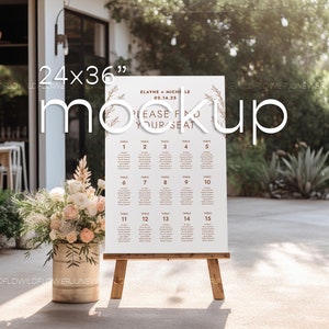 May include: A 24x36 inch wedding seating chart with a rustic, floral design. The chart is printed on white paper and features the names of guests and their assigned tables. The text reads "Elayne + Michele 02.14.25 Please Find Your Seat".