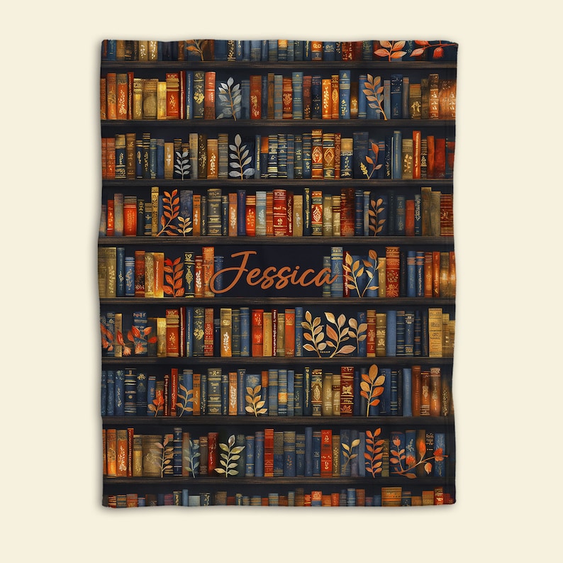 May include: A personalized throw blanket with a dark blue background featuring a bookshelf filled with colorful books and gold leaf accents. The name "Jessica" is written in orange script on the blanket.