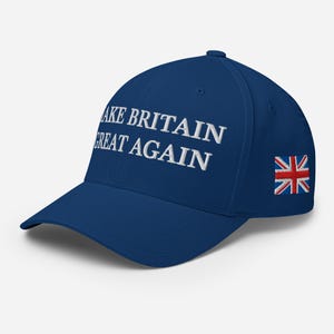 May include: A navy blue baseball cap with the embroidered text "MAKE BRITAIN GREAT AGAIN" in white. The cap features the Union Jack flag embroidered on the side.