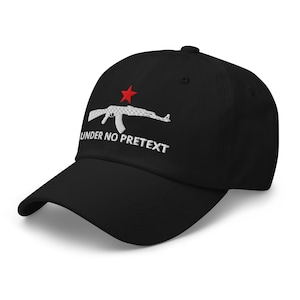 May include: Black baseball cap with a curved brim. The cap features a white embroidered image of a rifle with a red star above it. The text "UNDER NO PRETETX" is embroidered below the rifle in white.