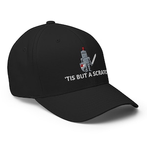 May include: Black baseball cap with a curved peak. The cap has an embroidered design of a knight with a sword and shield, and the text "'TIS BUT A SCRATCH" in white.