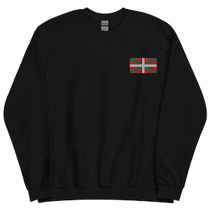 Peut inclure: Sweat-shirt noir avec un petit drapeau basque brodé sur le haut de la poitrine gauche. Le drapeau présente une croix blanche et un sautoir vert sur fond rouge. Le sweat-shirt est en matière douce.