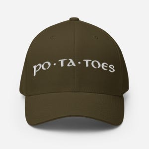 Könnte beinhalten: Olivgrüne Baseballkappe mit dem in Weiß gestickten Wort "po.ta.toes". Die Kappe hat einen gebogenen Schirm und eine strukturierte Passform. Der Text ist in einer stilisierten Schriftart gehalten.