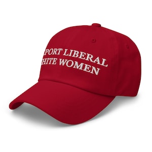 May include: A red baseball cap with the embroidered text "SUPPORT LIBERAL WHITE WOMEN" in white. The cap has a curved brim and a six-panel design, suitable for casual wear.