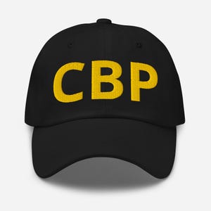May include: Black baseball cap with the embroidered letters "CBP" in yellow. The cap has a curved brim and a button on top. The letters are in a bold, blocky font.