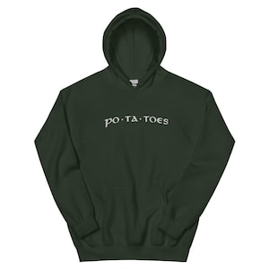 Peut inclure: Un sweat à capuche vert foncé avec le mot "potatoes" en texte blanc stylisé sur la poitrine. Le sweat-shirt a une poche avant et une capuche à cordon. Le tissu semble être une matière douce et confortable.