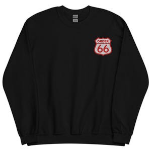 May include: Black sweatshirt with a Route 66-style emblem on the upper left chest. The emblem is red and white with the words "ORDER" above the number "66". The sweatshirt is made of a soft material.