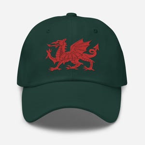 Puede incluir: Gorra de béisbol verde oscuro con un emblema de dragón galés rojo bordado. La gorra tiene una visera curva y una correa ajustable en la parte posterior, ofreciendo un estilo clásico y casual.