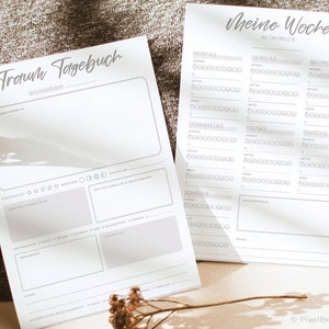 K&ouml;nnte beinhalten: Zwei druckbare Seiten zum Journalisieren von Tr&auml;umen und zur Verfolgung deiner Woche. Die erste Seite tr&auml;gt den Titel "Traumtagebuch" und hat Abschnitte zum Aufzeichnen des Traums, zur Bewertung des Traums und zum Notieren von Symbolen oder Themen. Die zweite Seite tr&auml;gt den Titel "Meine Woche" und hat ein Raster f&uuml;r jeden Tag der Woche mit Kreisen zur Bewertung deiner Stimmung.