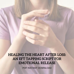 May include: A person wearing a light purple t-shirt with the text "HEALING THE HEART AFTER LOSS: AN EFT TAPPING SCRIPT FOR EMOTIONAL RELEASE PDF INSTANT DOWNLOAD". The person's hands are in the foreground.