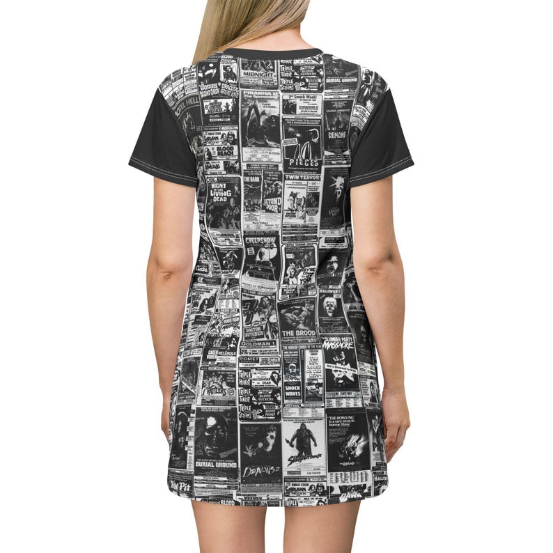 A flat-lay view of the back of a t-shirt dress showing the continuous black-and-white vintage horror poster print and solid black sleeves.
