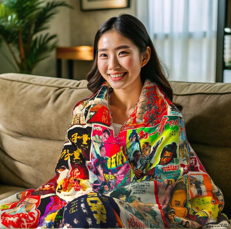 A woman sits on a brown sofa, smiling and wrapped in a blanket patterned with a collage of vintage Kung Fu movie posters.