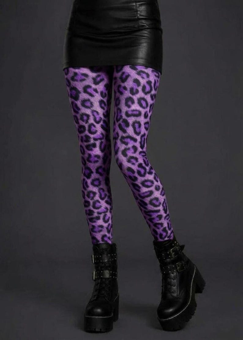 A person wearing purple and black leopard print leggings, a black miniskirt, and black platform combat boots.