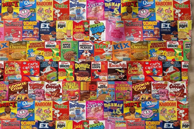 May include: A repeating pattern fabric featuring a collage of vintage cereal boxes including Mr. T, Quisp, Kaboom, Trix, Boo-Berry, Barbie, Pac-Man, Donkey Kong, E.T., Sugar Pops, Lucky Charms, Super Sugar Crisp, Pink Panther, and Cookie Crisp.