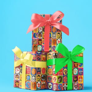 May include: Three gift boxes wrapped in colorful paper with images of wrestling masks. The top box is tied with a red ribbon, the middle box is tied with a yellow ribbon, and the bottom box is tied with a green ribbon.