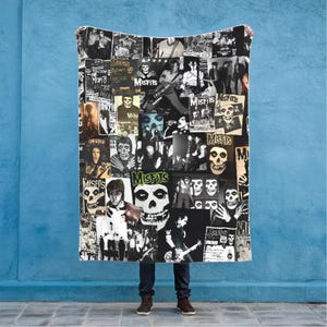 May include: A black and white blanket featuring a collage of images, including skulls, band members, and the word "Misfits." The blanket has a vintage, punk rock aesthetic.
