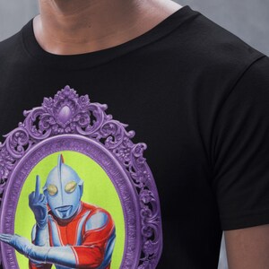 May include: Black t-shirt with a graphic of a retro superhero character giving the middle finger. The character is in red, blue, and silver, set against a lime green background within a purple ornate frame.