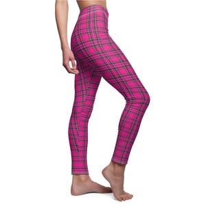 Side view of a person wearing bright pink and black plaid print leggings.