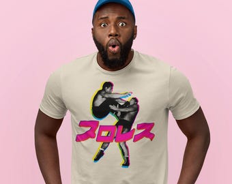 May include: A beige t-shirt with a black and white image of two wrestlers in a fighting pose. The text "プロレス" is printed in pink, yellow, and blue letters below the image.