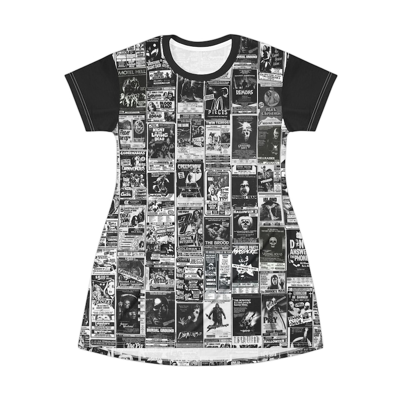 A flat-lay view of the front of a t-shirt dress displaying an all-over black-and-white print of various vintage horror movie posters and solid black sleeves.