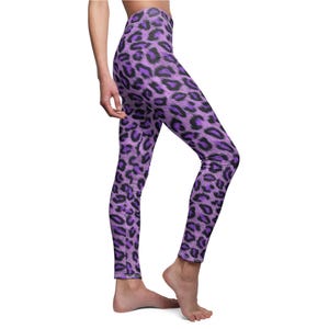 Side view of a person wearing purple and black leopard animal print leggings.