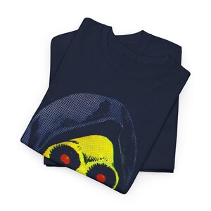 Two folded navy blue t-shirts, with the top one showing a partial graphic of a yellow skull with red eyes in a blue hood.