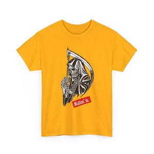 A plain yellow t-shirt laid flat, printed with a black and white grim reaper graphic and red lettering.