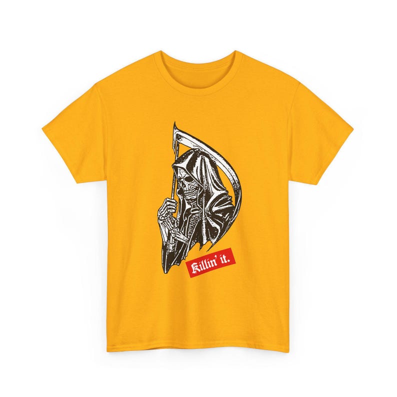 A plain yellow t-shirt laid flat, printed with a black and white grim reaper graphic and red lettering.
