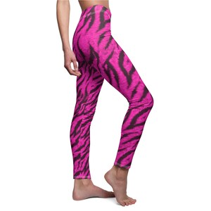 Side view of a person wearing bright pink and black tiger stripe print leggings.