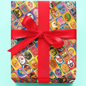 May include: A red ribbon tied around a gift box wrapped in colorful wrapping paper featuring a pattern of luchador wrestling masks.