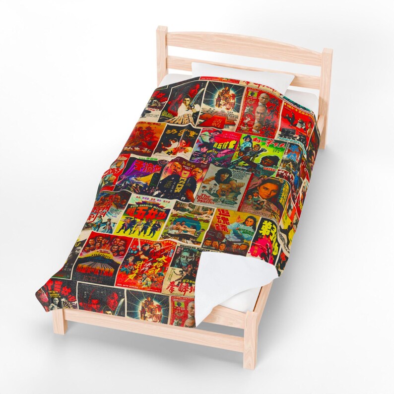 A blanket patterned with a collage of vintage Kung Fu movie posters covers a light wooden bed frame with a white sheet.