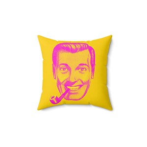 A square yellow throw pillow with a magenta and yellow pop-art style face of a man smoking a pipe is centered on a white background.