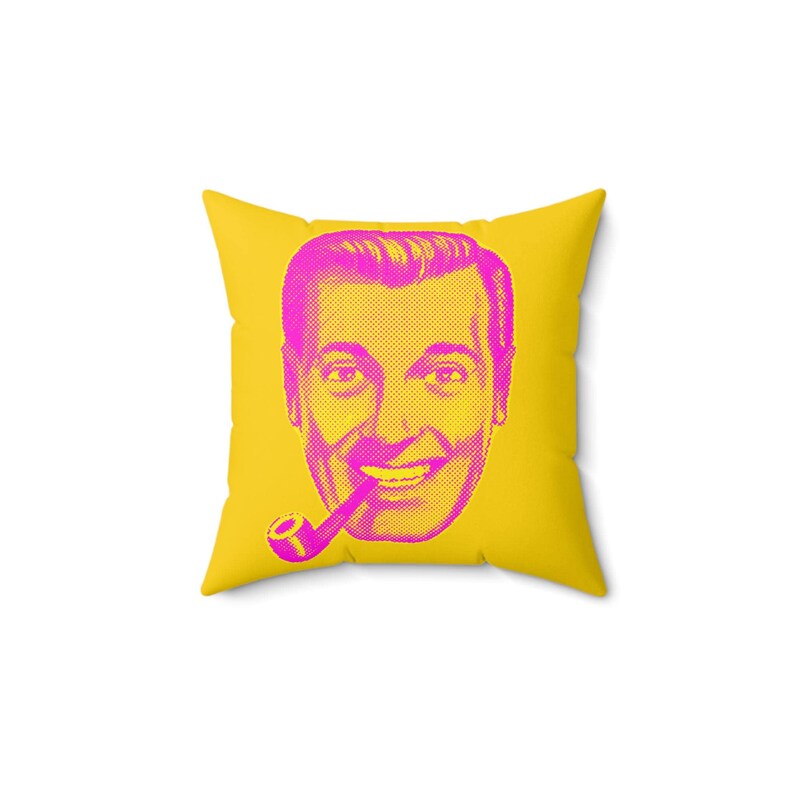 A square yellow throw pillow with a magenta and yellow pop-art style face of a man smoking a pipe is centered on a white background.