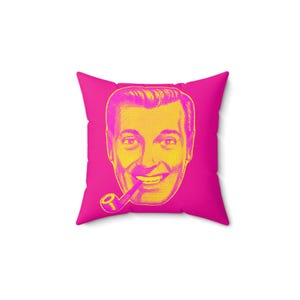 A square throw pillow with a hot pink background and a yellow halftone image of a man smoking a pipe.