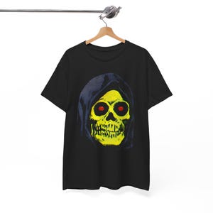 A black t-shirt with a yellow skull in a blue hood hangs on a wooden hanger against a white background.